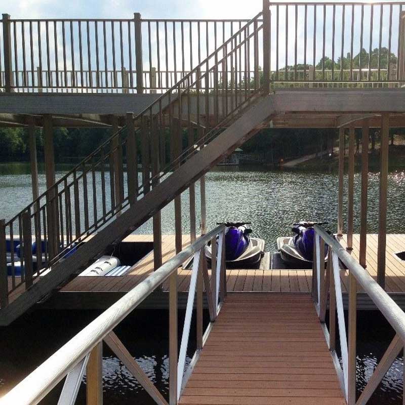Walkway up to brown dock with jet skis